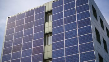 solar panels for generating electricity on the wall of an industrial building in the city during the day